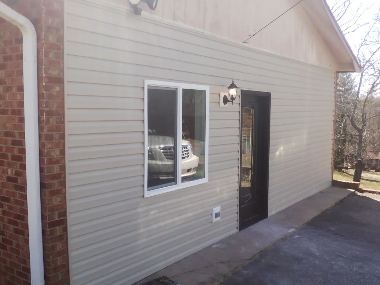 New vinyl siding and entry door on a room addition in Defiance