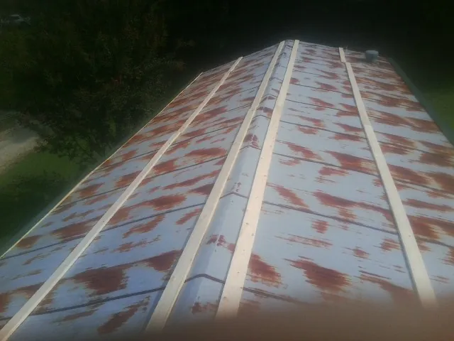 Rusted metal roof panels with new wood purlins before replacement — Storm Damage Roof Repair in Defiance by Roofing Brothers